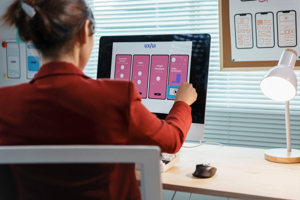 Web designer working on user experience for mobile application using wireframe on computer in office | Quest Mindshare Research team comparing findings from market research vs. user research