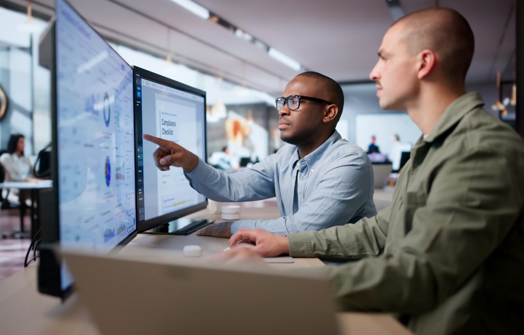 Two Men Analyze Compliance Data Together | Quest Mindshare Marketing team reviewing first-party data alongside survey research results