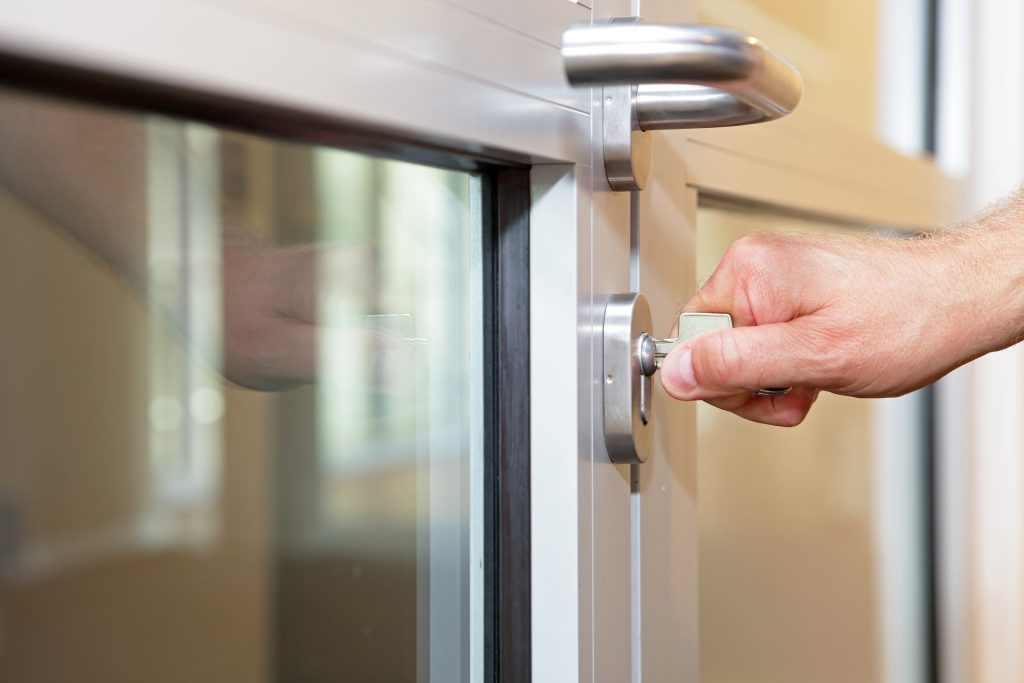 hand opening lock with typical key in office door - close up | Quest Mindshare Padlock on a laptop, showing how data integrity starts by locking out survey fraud