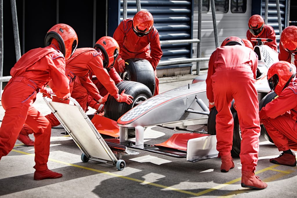 Racing team working at pit stop | Quest Mindshare Pit crew working together, like a research team balancing speed and quality in market research
